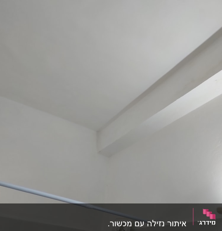 תקרה לבנה עם קורה, מוט תלייה ומתקן מגבות